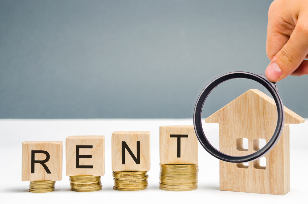 Magnifying glass, wooden blocks with the word Rent,
